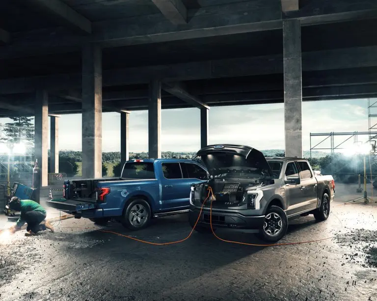 dos camiones eléctricos Ford en un sitio de trabajo