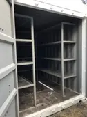 contenedor de embarque blanco con estantes en el interior y ambas puertas abiertas
