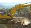 Excavadora Kobelco amarilla y gris excavando rocas y tierra en un sitio de trabajo
