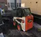 Cargador compacto de 600 – 850 lb BOBCAT blanco, negro y naranja