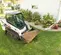 Cargador sobre orugas compacto BOBCAT blanco y negro sobre césped con suciedad en la cubeta