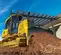 Buldócer con baja presión sobre el suelo John Deere amarillo que sube suciedad por una pendiente