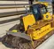 Buldócer con baja presión sobre el suelo John Deere amarillo 