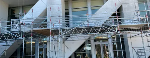 andamiaje frente a escalones fuera de un edificio de oficinas