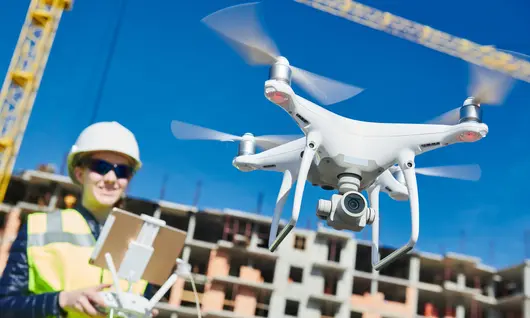 female drone pilot operating uav on construction site