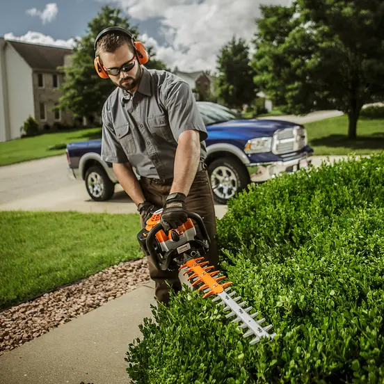 Podador de setos con cuchilla de 30 pulgadas Stihl naranja que se utiliza para cortar setos